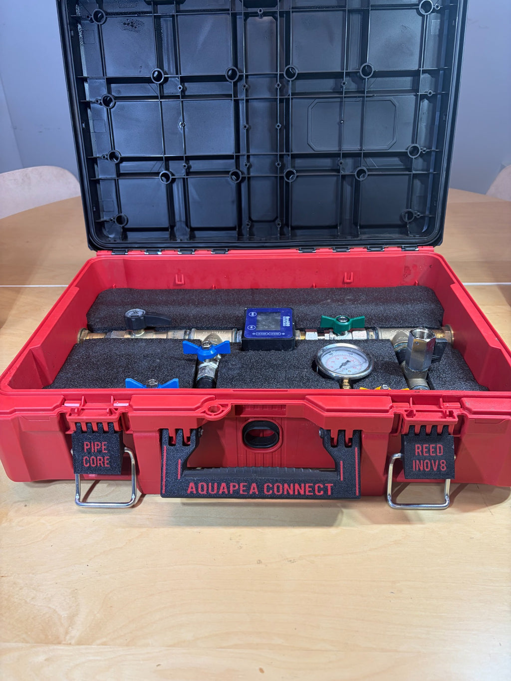 Aquapea Connect equipment in its open red carry case, viewed from the front